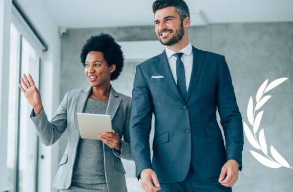 a man and a woman in business attire standing next to each other.